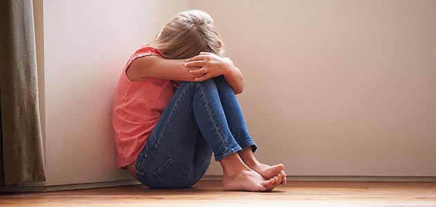El abuso sexual a niños Niña acurrucada en rincón