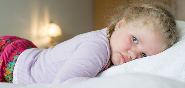 Niña en la cama triste