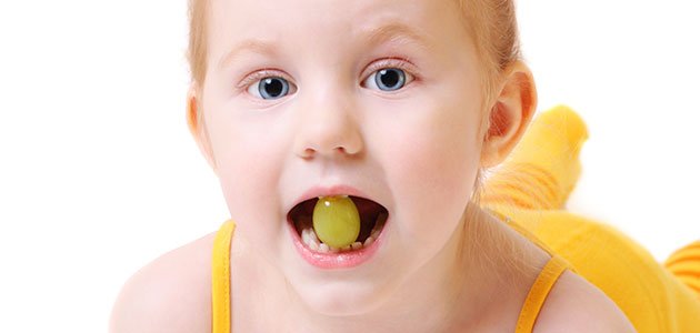 Cómo actuar ante el atragantamiento del bebé Niña con uva en la boca
