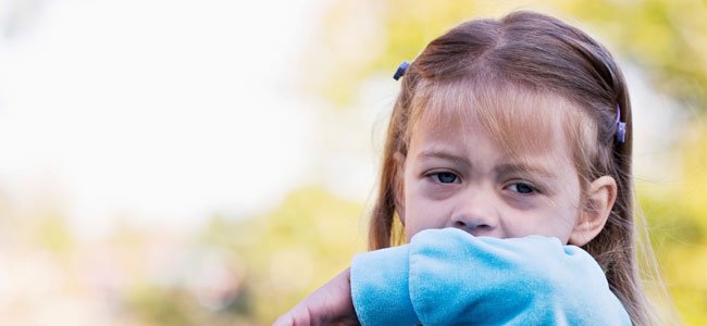Niña se tapa la cara con manga