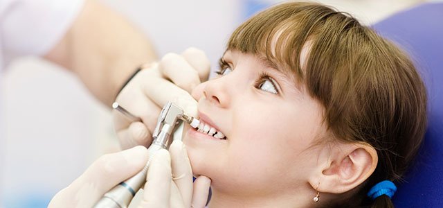 Las caries en niños y bebés Niña en el dentista