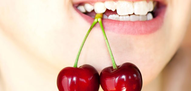 Prevenir la caries en dientes más propensos a tenerlas Dientes muerden cerezas