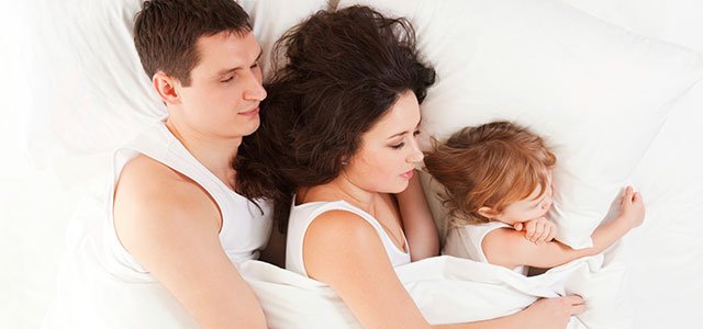 Pareja con niño en la cama