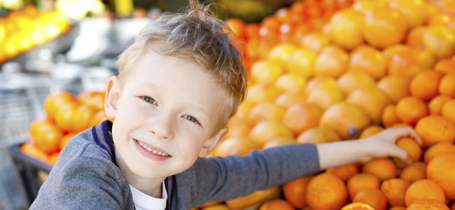 NIño coge naranja